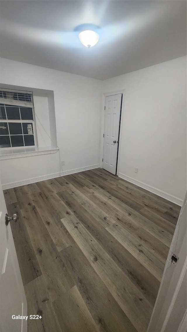 unfurnished room featuring baseboards and hardwood / wood-style floors