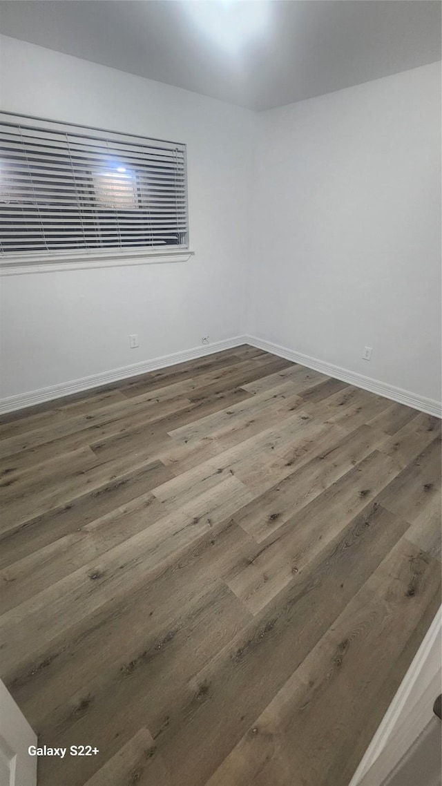 unfurnished room featuring wood finished floors and baseboards