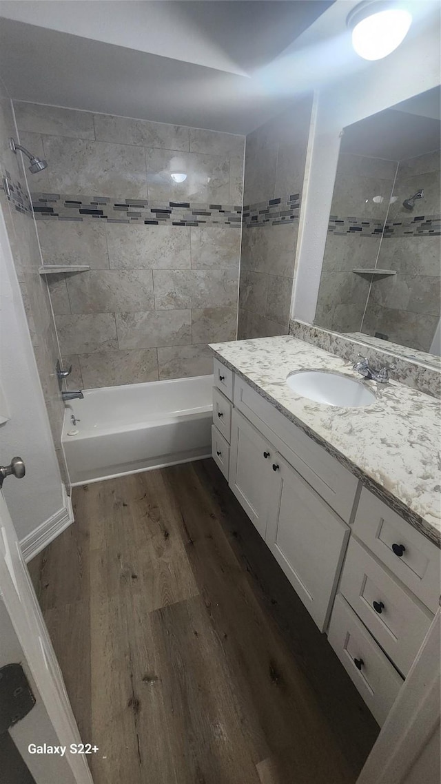 bathroom featuring bathtub / shower combination, wood finished floors, and vanity