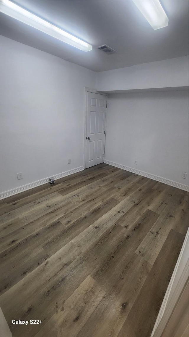 unfurnished room with visible vents, baseboards, and wood finished floors