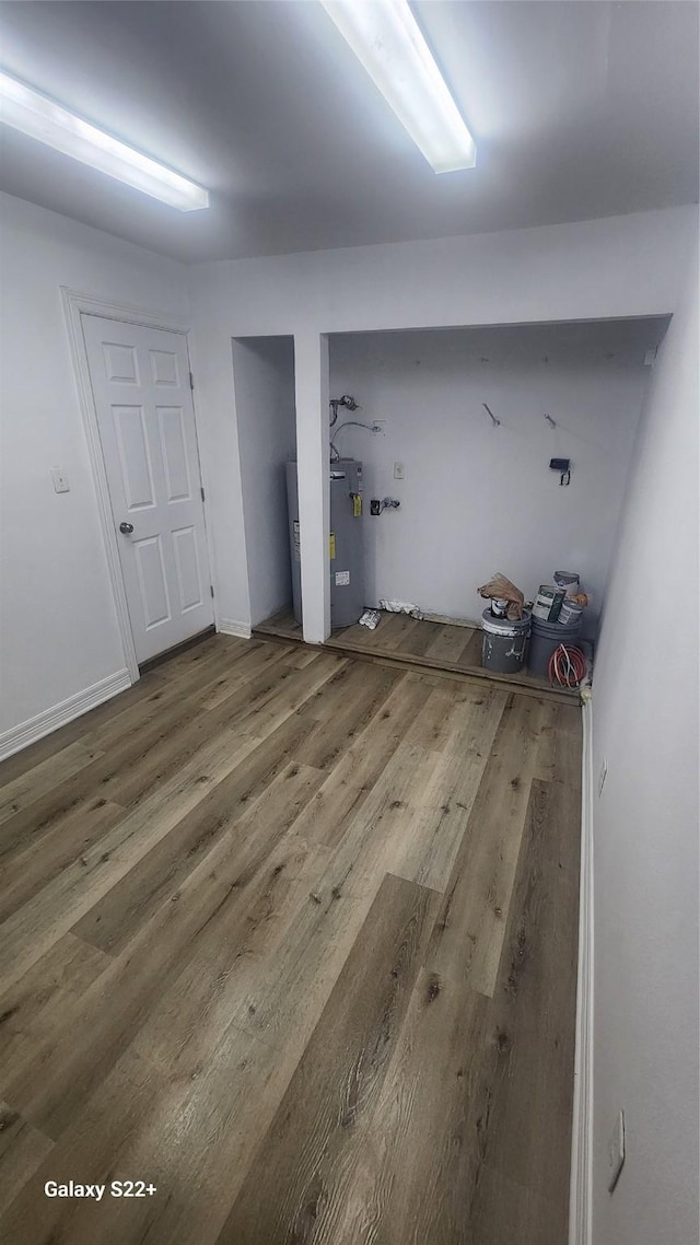 clothes washing area featuring baseboards and wood finished floors