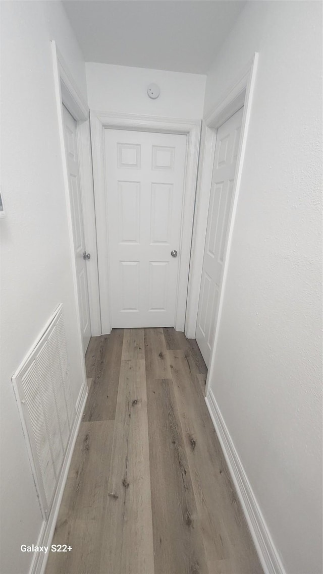 hallway with light wood finished floors and visible vents