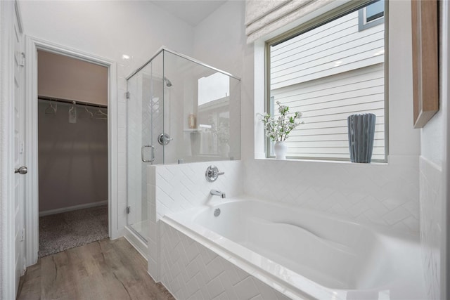 bathroom with independent shower and bath and hardwood / wood-style flooring