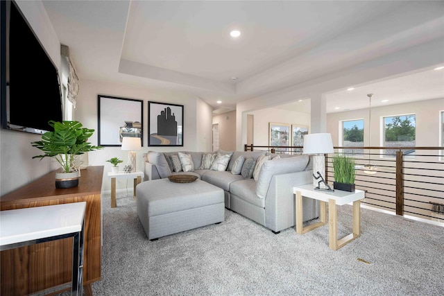 living room with light carpet and a tray ceiling