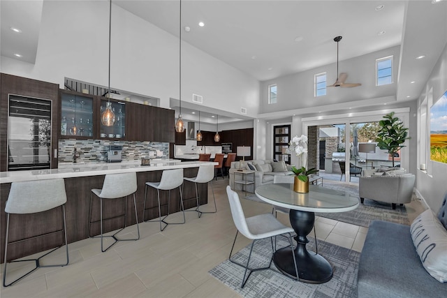 dining room with a high ceiling and ceiling fan