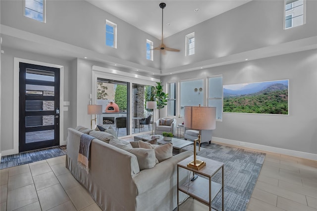 living room with a towering ceiling and ceiling fan