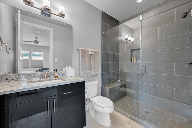 bathroom featuring ceiling fan, vanity, an enclosed shower, tile patterned floors, and toilet