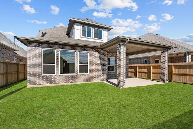 back of property with a lawn and a patio area