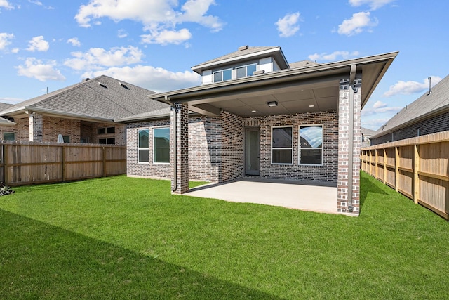 rear view of house featuring a lawn and a patio