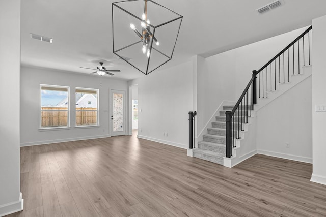 entrance foyer featuring ceiling fan with notable chandelier and hardwood / wood-style floors