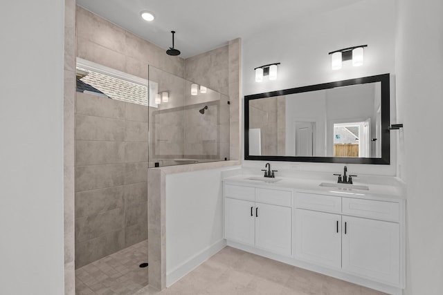 bathroom featuring tiled shower and vanity