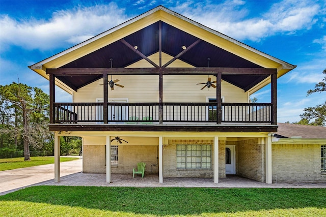 back of property with a yard, ceiling fan, and a patio area