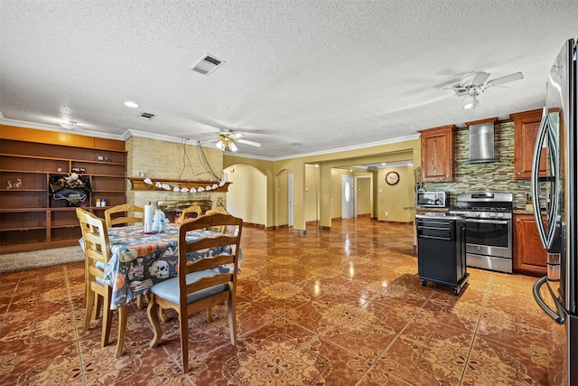 tiled dining room featuring a brick fireplace, a textured ceiling, ornamental molding, and ceiling fan