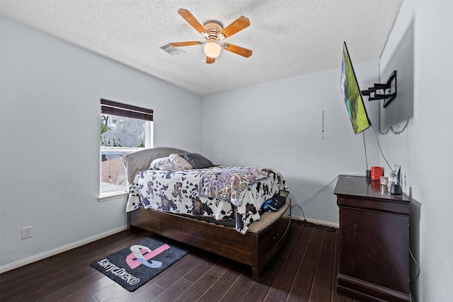 bedroom featuring ceiling fan, dark hardwood / wood-style floors, and a textured ceiling