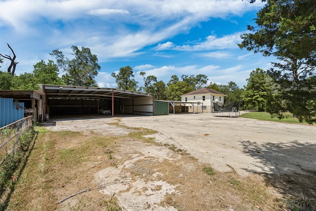 view of yard featuring a carport and a trampoline