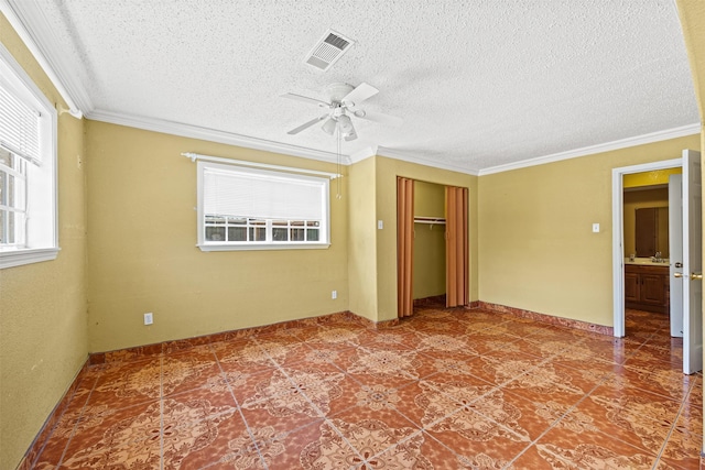 unfurnished bedroom featuring crown molding, a closet, multiple windows, and a textured ceiling