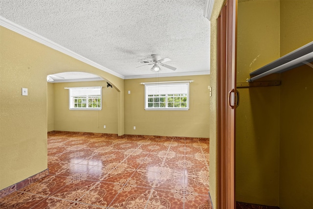 spare room with ornamental molding, a healthy amount of sunlight, ceiling fan, and a textured ceiling