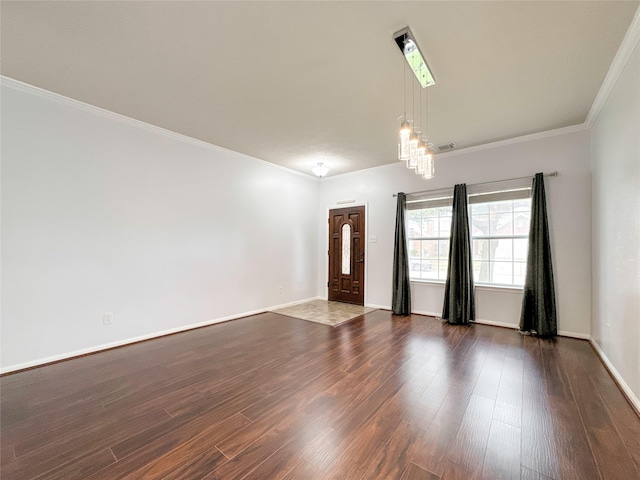 empty room featuring dark wood-type flooring and crown molding
