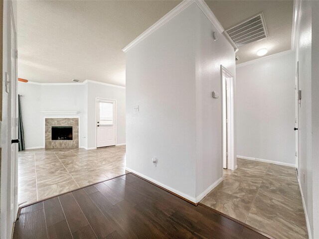 unfurnished living room featuring a fireplace, ornamental molding, and wood-type flooring