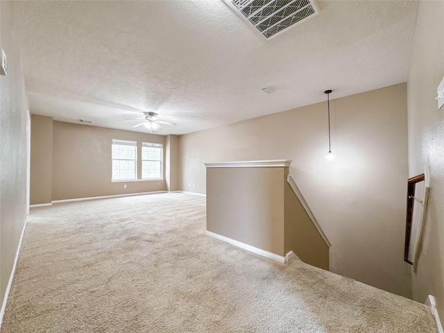 empty room featuring carpet floors, a textured ceiling, and ceiling fan