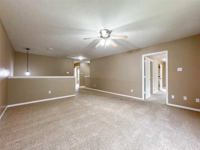 unfurnished room with light colored carpet, a textured ceiling, and ceiling fan