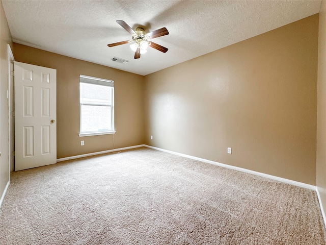 spare room featuring a textured ceiling, ceiling fan, and carpet