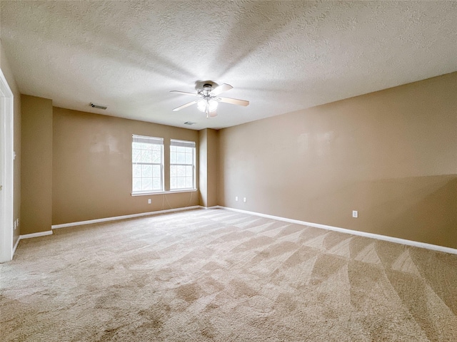 carpeted empty room with ceiling fan and a textured ceiling