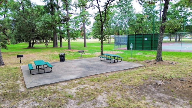 view of community featuring a yard and tennis court