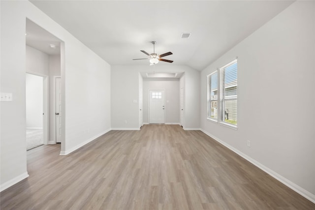 unfurnished living room featuring visible vents, baseboards, lofted ceiling, light wood-style flooring, and ceiling fan