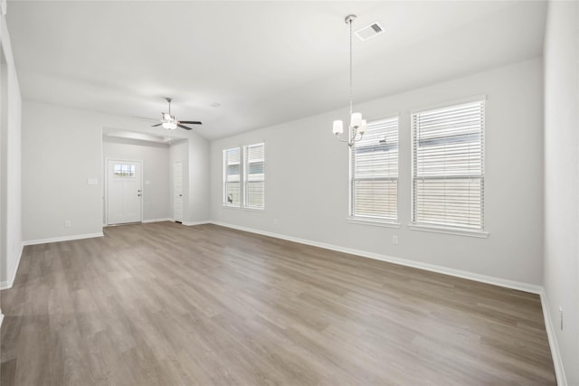 spare room featuring a wealth of natural light, visible vents, baseboards, and wood finished floors