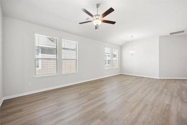 unfurnished room featuring baseboards, visible vents, vaulted ceiling, light wood-style floors, and ceiling fan with notable chandelier