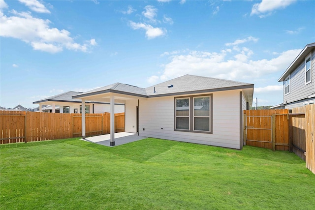 back of house featuring a patio, a lawn, and a fenced backyard