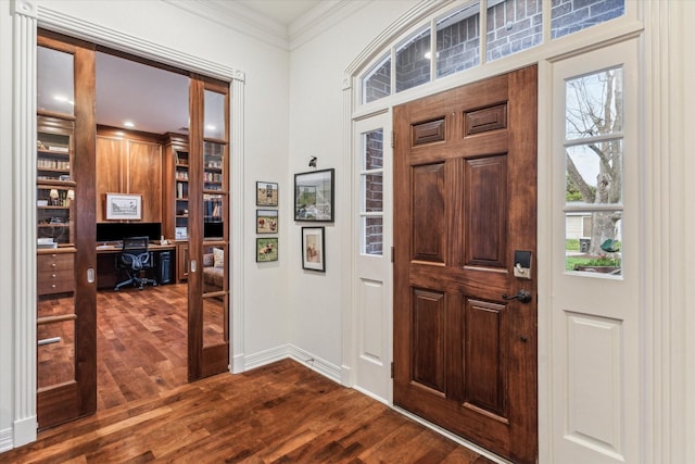 entryway with dark wood finished floors, crown molding, and baseboards