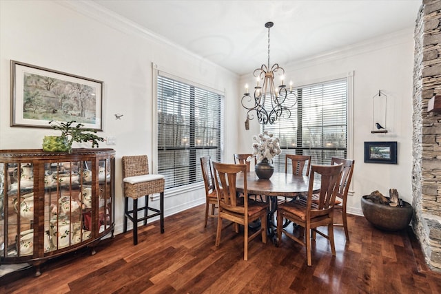 dining room featuring a healthy amount of sunlight, a notable chandelier, crown molding, and wood finished floors