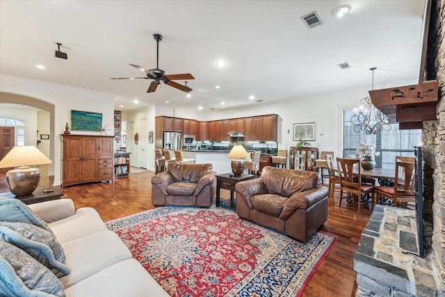 living area with arched walkways, wood finished floors, visible vents, and recessed lighting