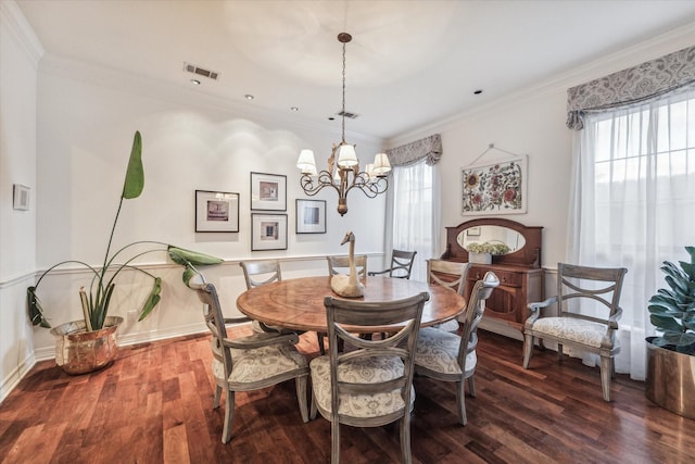 dining space featuring crown molding, a chandelier, plenty of natural light, and wood finished floors