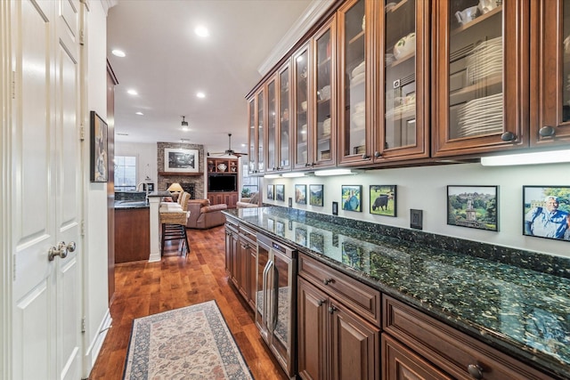 bar with ceiling fan, wine cooler, recessed lighting, a large fireplace, and dark wood-type flooring