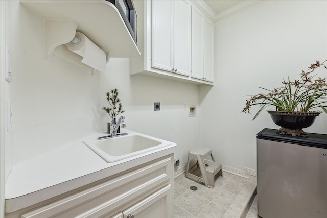 washroom featuring a sink, baseboards, ornamental molding, cabinet space, and electric dryer hookup