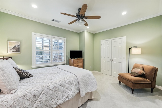 bedroom with a closet, visible vents, crown molding, and light colored carpet