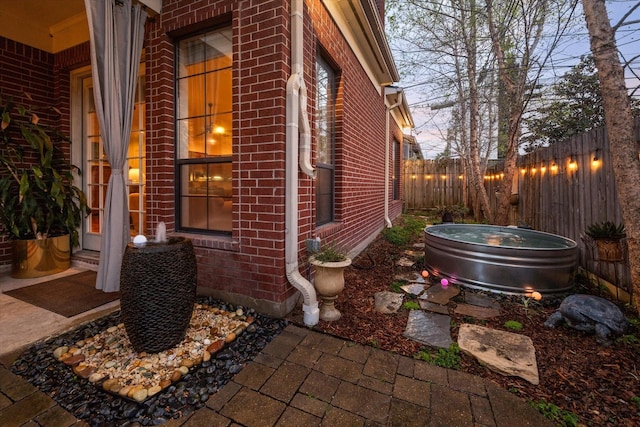 view of property exterior featuring fence private yard and brick siding