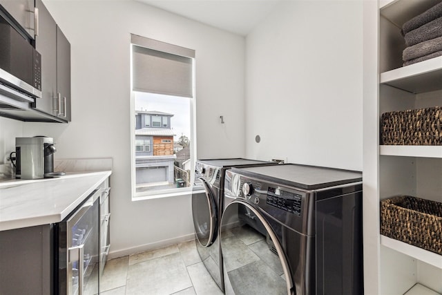 washroom featuring cabinets, wine cooler, and independent washer and dryer