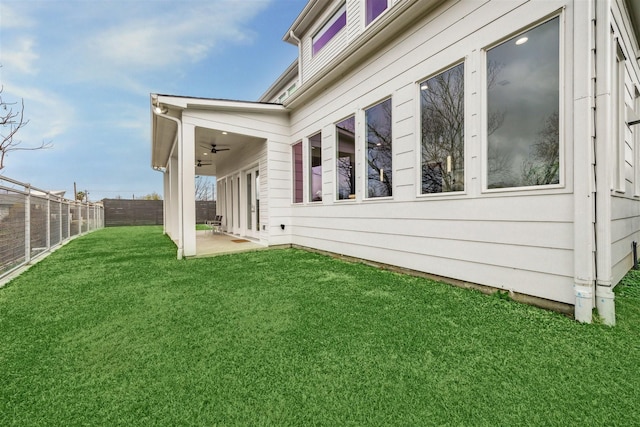 view of property exterior with ceiling fan, a yard, and a patio