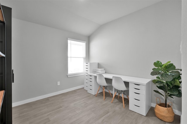 home office with lofted ceiling and light hardwood / wood-style flooring