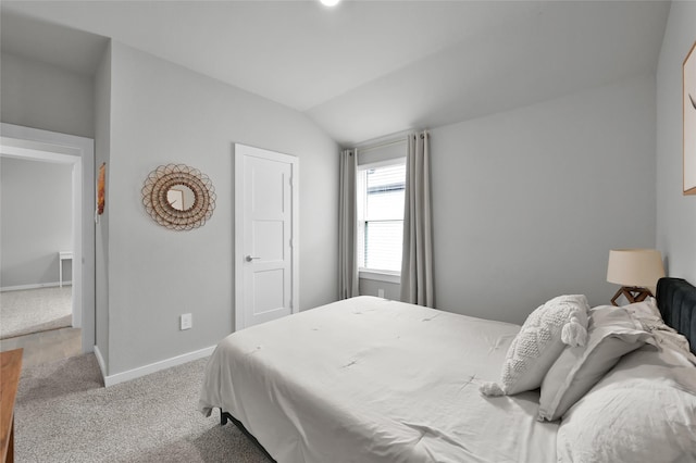 carpeted bedroom with lofted ceiling