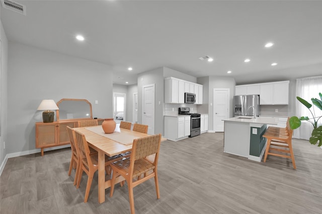 dining area with light hardwood / wood-style floors and a healthy amount of sunlight