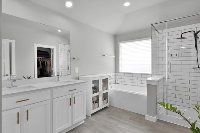 bathroom featuring independent shower and bath, vanity, lofted ceiling, and hardwood / wood-style floors