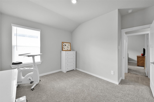 office space with lofted ceiling and light carpet