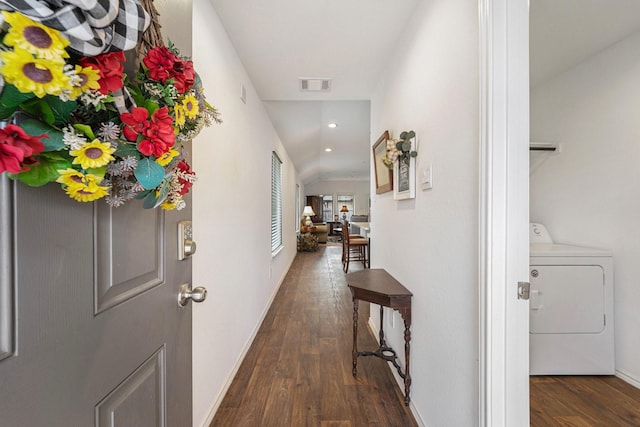 corridor featuring dark hardwood / wood-style flooring, washer / dryer, and vaulted ceiling