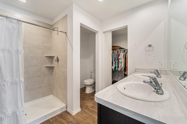 bathroom with wood-type flooring, curtained shower, vanity, and toilet