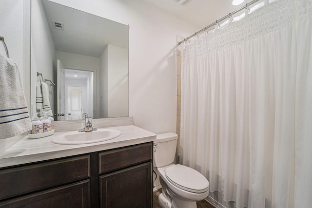 bathroom with walk in shower, vanity, and toilet